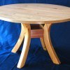 The small round wood kitchen table with rough wood and metal holders will beautify any interior.